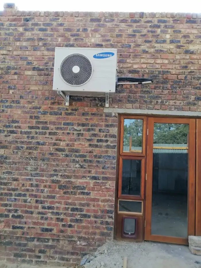 Samsung outdoor unit installed above a doorway by SJS Cooling